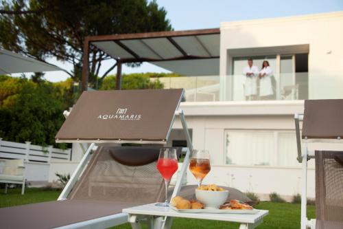 - une table avec deux verres de vin et une assiette de nourriture dans l'établissement Aquamaris Design Suite & Spa, à Paestum