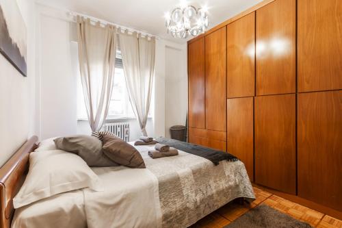 1 dormitorio con 1 cama grande y cabecero de madera en Rossini Apartment, en Milán