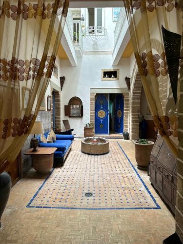 sala de estar con sofá azul y chimenea en Riad Al Zahia, en Essaouira