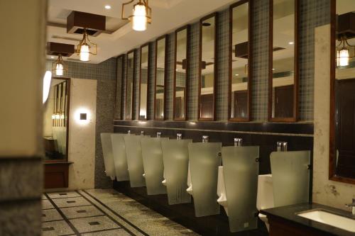 a bathroom with a row of urinals on a wall at Grand Heritage Hotel & Resort in Ludhiana