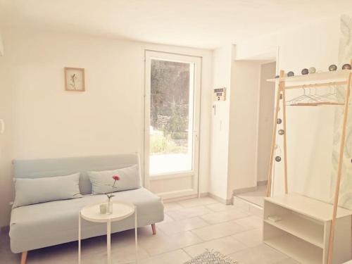 sala de estar con sofá y mesa en Belle dépendance de 30m2 avec terrasse et jardin, en Villeneuve-lès-Avignon