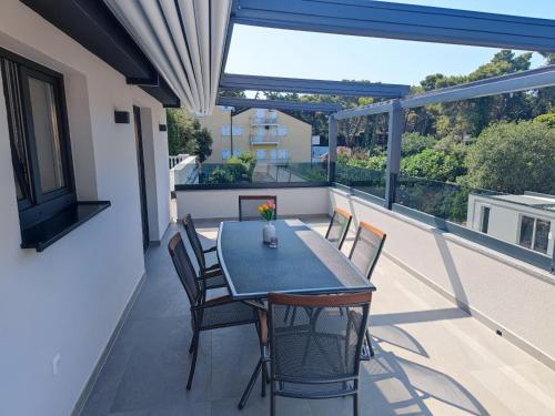 a patio with a table and chairs on a balcony at Apartmani Ante & Ivano Biograd in Biograd na Moru
