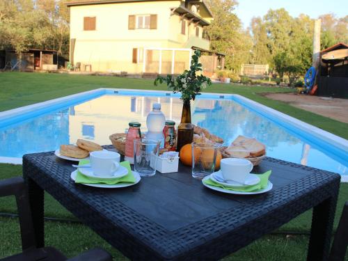 a table with food and drinks on it next to a pool at Country & Beach B&B in Capoterra