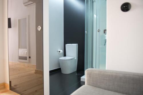 La salle de bains est pourvue de toilettes et d'une porte en verre. dans l'établissement Páteo Saudade Lofts, à Lisbonne