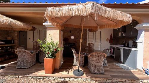 a patio with chairs and an umbrella on a house at Chez Virginie in Porto-Vecchio