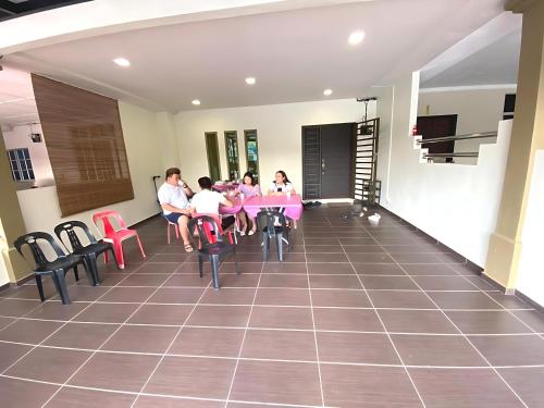 a group of people sitting at tables in a restaurant at Relax Inn 200 旅安居 -3BR homestay near Alor Setar Mall in Alor Setar