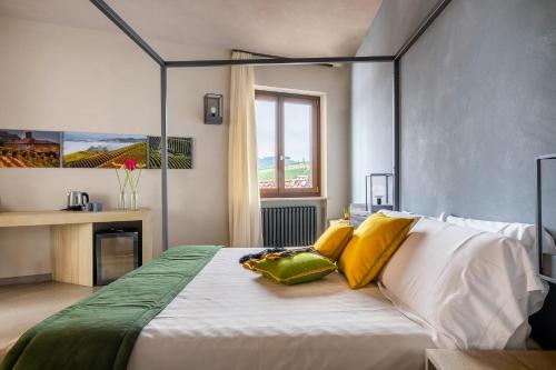 1 dormitorio con 1 cama con almohadas amarillas y verdes en CasaCastello Barolo, en Barolo