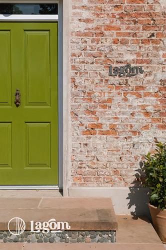a green door on the side of a brick building at StayLagom in Ballycastle