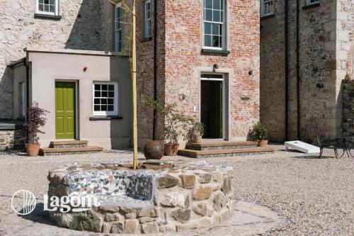 a tree in front of a building with a fountain at StayLagom in Ballycastle