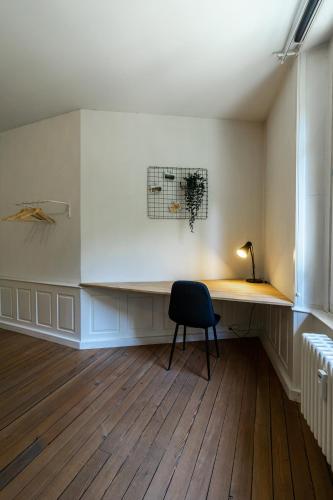 a room with a desk with a chair and a lamp at Historische Wohnung im Herzen der Thuner Altstadt in Thun