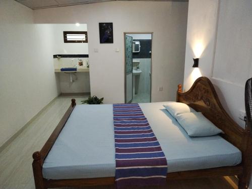 a bedroom with a bed with a blue blanket on it at Nethmi Homestay & Restaurant in Tangalle