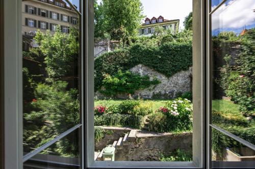 a window with a view of a garden at Historische Wohnung im Herzen der Thuner Altstadt in Thun