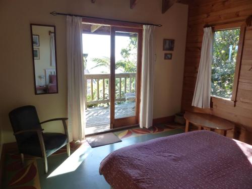 a bedroom with a bed and a window and a chair at The Old Slaughterhouse Traveller's Lodge in Hector