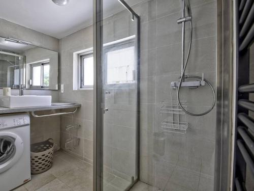 a bathroom with a shower and a sink and a washing machine at Arcachon Pereire - T2 front de mer avec terrasse et parking, accès direct plage - FR-1-433-24 in Arcachon