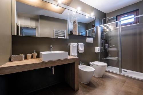 a bathroom with a sink and a toilet and a shower at CasaCastello Barolo in Barolo