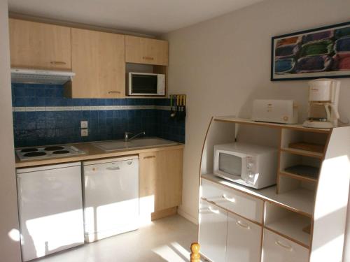 eine kleine Küche mit weißen Schränken und einer Mikrowelle in der Unterkunft Appartement Saint-Lary-Soulan, 3 pièces, 6 personnes - FR-1-457-130 in Saint-Lary-Soulan