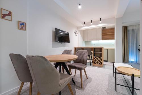 a living room with a table and chairs and a kitchen at Bonita Residence in Dobrota