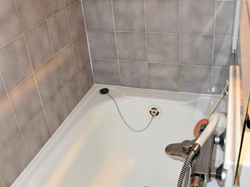 eine weiße Badewanne mit einem Schlauch im Bad in der Unterkunft Studio Saint-Jean-d'Aulps, 1 pièce, 4 personnes - FR-1-573-116 in Saint-Jean-dʼAulps