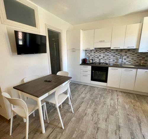 a kitchen with white cabinets and a table and chairs at Vianova in Pietrapertosa