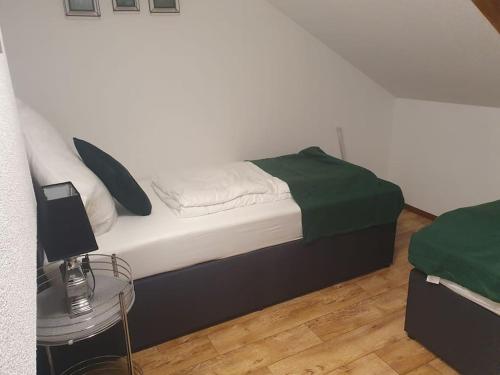 Schlafzimmer mit einem Bett mit grünen und weißen Kissen in der Unterkunft Waterfalls Apartment in Triberg