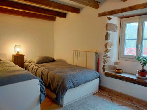 a bedroom with two beds and a window at Eyhera Perkain in Aldudes