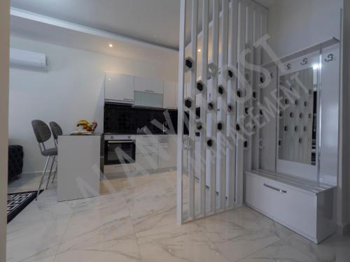 a white room with a staircase and a kitchen at Calypso Residence in Kestel Alanya E5 in Alanya