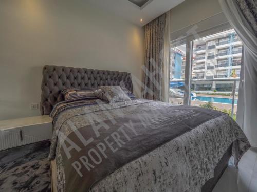 um quarto com uma cama grande e uma janela grande em Calypso Residence in Kestel Alanya E5 em Alanya