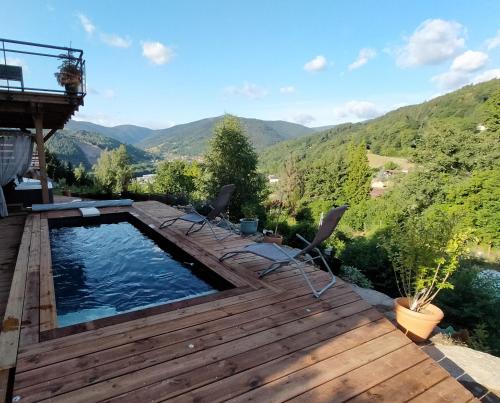a swimming pool on a deck with mountains in the background at Au chalet de JO in Muhlbach-sur-Munster
