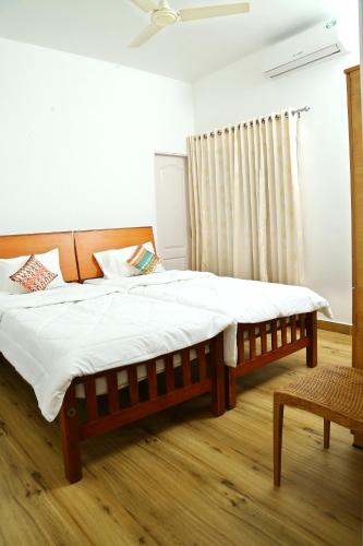 Postel nebo postele na pokoji v ubytování Tess Holistay Fort Kochi