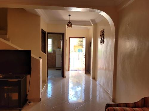 a hallway with a living room with a television and a door at Duplex avec piscine - Sidi Bouzid in El Jadida