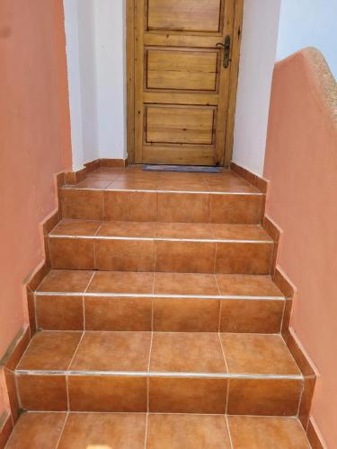 a set of stairs with a wooden door at Duplex avec piscine - Sidi Bouzid in El Jadida