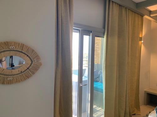 a mirror hanging on a wall next to a bedroom at Sunset junior suites in Agios Ioannis Tinos