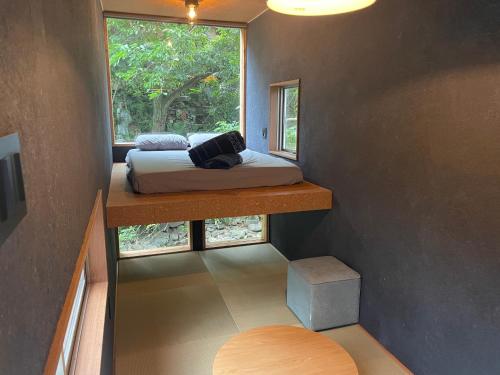 MEKIKI古民家 في ياماناشي: غرفة صغيرة بها سرير ونافذة