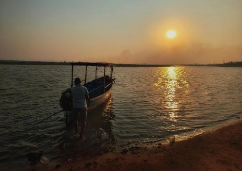 a woman standing next to a boat in the water at Wild Dunes Konark in Bālighāi
