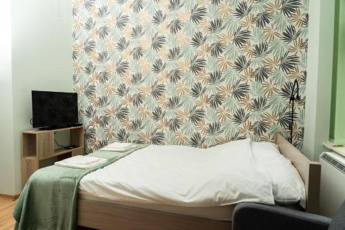 uma cama num quarto com uma parede em Studio Asnyka Old Town na Cracóvia