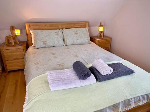 a bedroom with a bed with two towels on it at Field View in Braunston