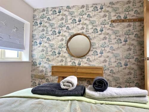um quarto com uma cama com toalhas e um espelho em Field View em Braunston