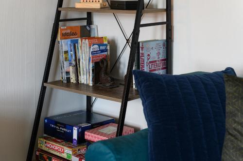 a book shelf filled with books next to a couch at Cludfan (Cosy Place) - in the heart of Llandudno in Llandudno