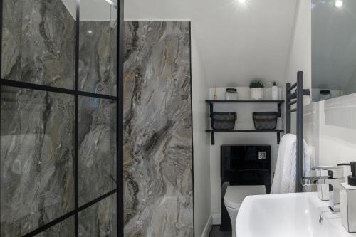 een badkamer met een douche, een toilet en een wastafel bij Cludfan (Cosy Place) - in the heart of Llandudno in Llandudno