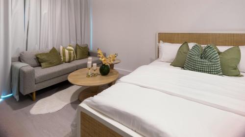 a bedroom with a large bed and a couch at Delightful Staycation in Masdar in Al Qurayyah