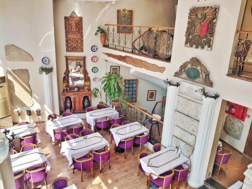 un restaurante con mesas blancas y sillas moradas en Orient Mintur Hotel, en Estambul