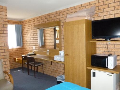 a room with a bathroom with a sink and a mirror at Royal Palms Motor Inn in Coffs Harbour