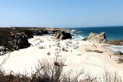 a group of people on a beach near the ocean at duArteLoft in Sines