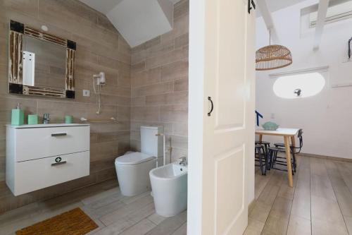 a bathroom with a toilet and a sink and a table at duArteLoft in Sines