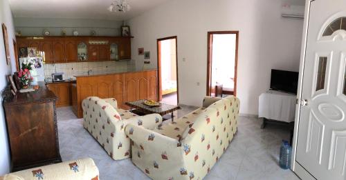 a living room with couches and a table and a kitchen at Dina House in Himare