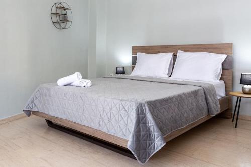 een slaapkamer met een groot bed met een grijs dekbed bij Sunny studio apartment in Thessaloniki city center in Thessaloniki