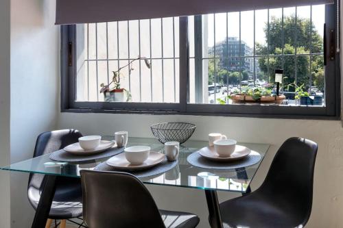 une table à manger avec des chaises et une fenêtre dans l'établissement Sunny studio apartment in Thessaloniki city center, à Thessalonique