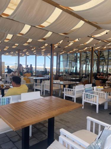 a restaurant with a wooden table and white chairs at квартира в ЦО Радуга Иссык Куль9 Raduga Issyk Kul in Chon-Sary-Oy