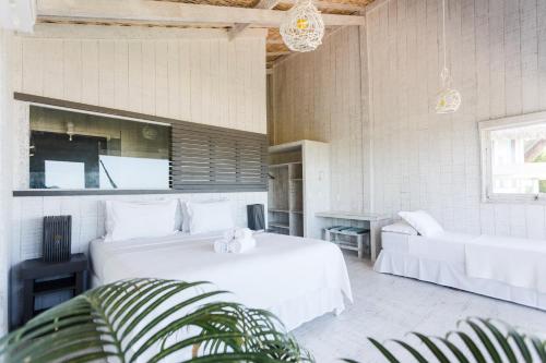 a bedroom with a large white bed and a couch at Beach Houses Moitas in Amontada