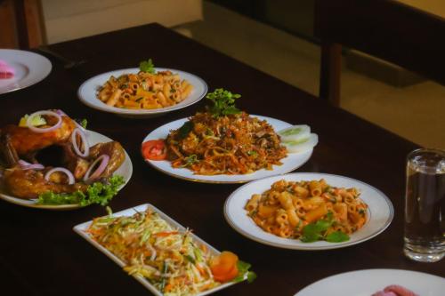 a table with plates of food on a table at Aryan Beach Villa in Wadduwa